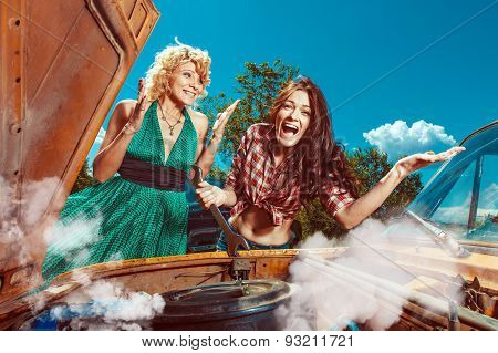 Beautiful Woman Mecanic Is Repairing A Car Another Woman Is Watching.