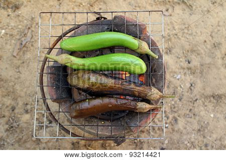 Grilling eggplants on earthen stove
