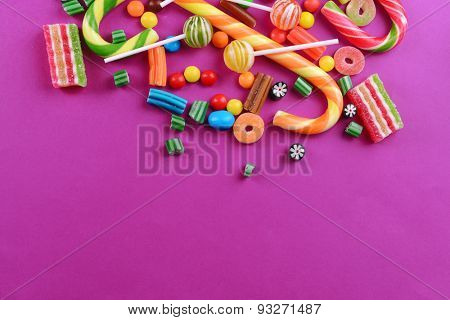 Colorful candies on purple background