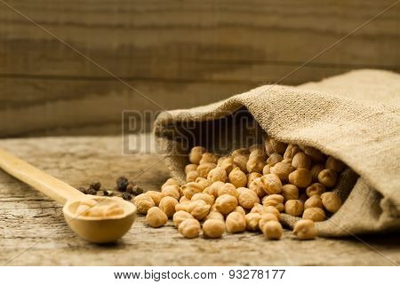 Scattered Chickpeas From A Jute Bag With A Spoon On Old Wooden Background