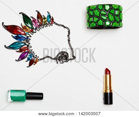 flat lay feminini accessories collage with glasses high heel shoes mascara lipstick bracelet earrings necklace and bow tie clips on white background.