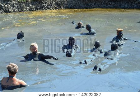 TEMRYUK DISTRICT, RUSSIA - AUGUST 29, 2015: Unknown happy campers bathing in mud volcano Tizdar on Azov Sea