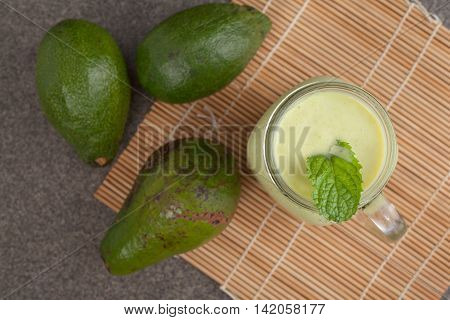 Avocado green smoothie and mint on bambo mat