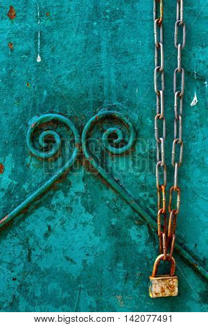 Background with a rusty chain with a lock on old gate.