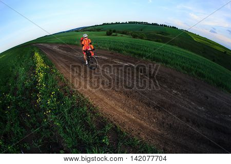 Tourist with backpack travels by bicycle on sunset