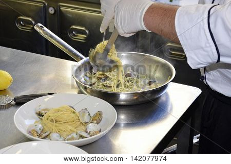 Preparetion dish of spaghetti with clams in a restaurant kitchen