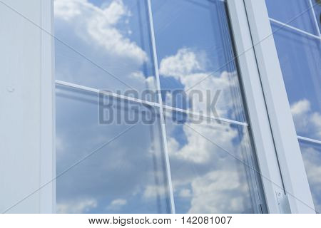 Plastic white window muntin bars with the reflection of the blue cloudy sky