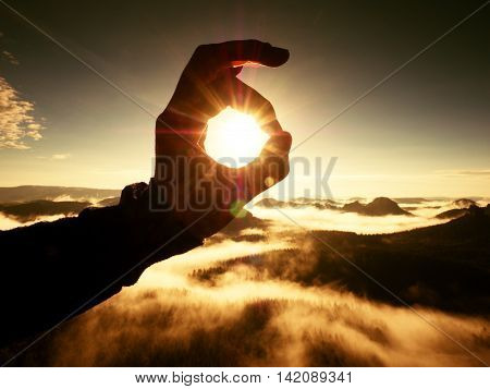 Man Hand Touch Sun. Misty Daybreak In A Beautiful Hills.