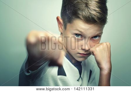 Angry child boy in white t-shirt training box punch.
