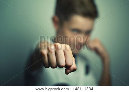 Angry child boy in white t-shirt training box punch.