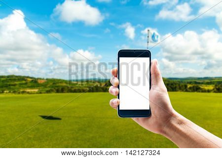 Hand using smartphone mobile in the vertical position, background blur of golf.