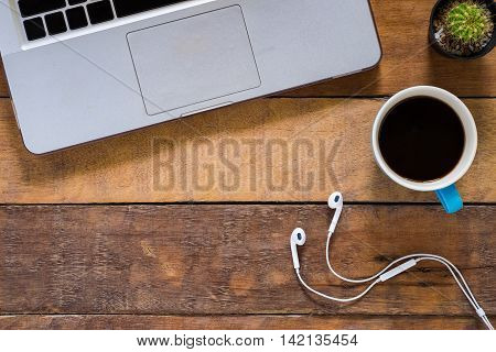 Office desk table with laptop cup of coffee and headphone. Top view workspace.
