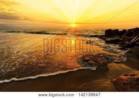 Ocean sunset sun rays is a colourful ocean scenic with sun beams bursting forth from the sun in a vivid surreal seascape.