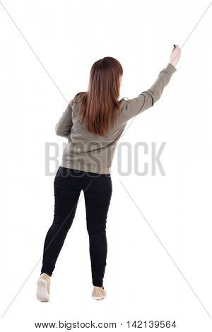 back view of writing beautiful woman. Rear view people collection.  backside view of person. Isolated over white background. A young girl in a gray sweater pulled up with a felt-tip pen in a hand.