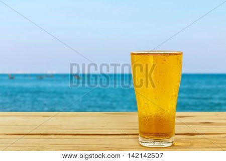 Beer glass on a blurred background of the sea.