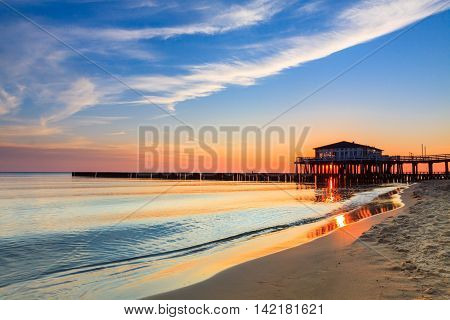 Restaurant at wooden pier on the baltic sea during sunrise. Ustronie Morskie Poland.