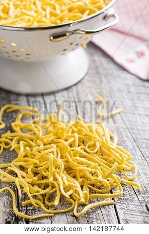 Tasty spaetzle pasta on old kitchen table.