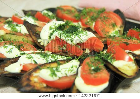Fried eggplants and fresh tomato with souce and herbs