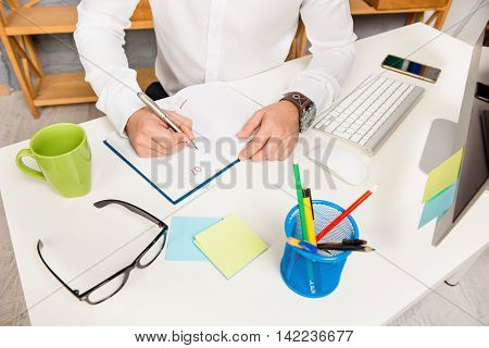 Close up photo of businessman writting plan for day in daybook