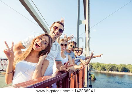 Joyful Excited Best Friends Having Fun And Showing V-sign With Fingers Standing On Bridge