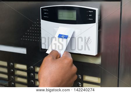 Close-up Of Businessperson's Hand Holding Keycard To Open Door