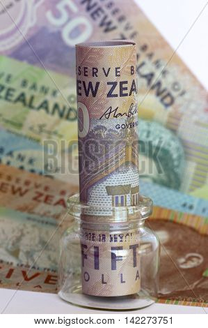 New Zealand dollars in a glass jar.