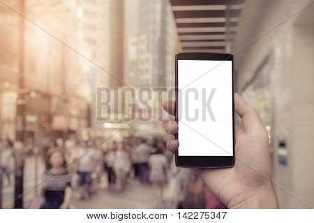 man hand holding the phone and white screen with walking street blur background. Smart phone with blank screen and can be add your texts or others on smart phone. vintage