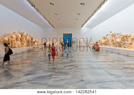 OLYMPIA, GREECE - AUGUST 08, 2016: People in the main room of the Archaeological museum in Olympia with statues from the temple of Zeus on August 08, 2016.