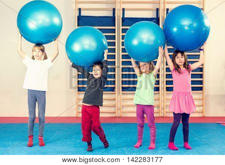 Children at physical education class playing with fitness balls