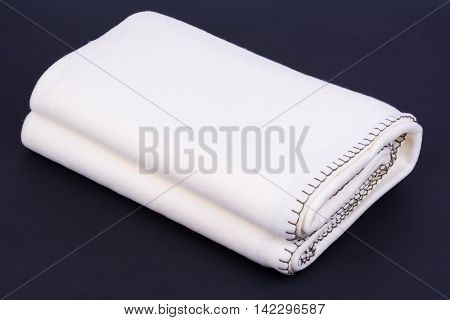 Warm white wool blanket on dark background