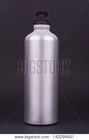 Silver aluminum water bottle on dark background