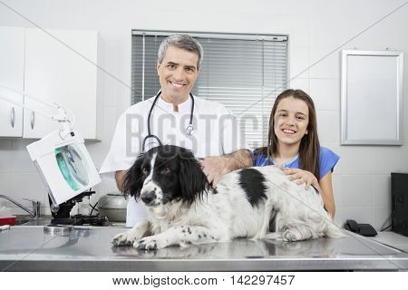 Male Doctor And Girl With Border Collie On Table