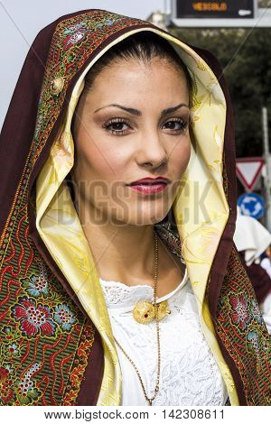 QUARTU S.E., ITALY - September 21, 2014: Parade of Sardinian costumes and floats for the grape festival in honor of the celebration of St. Helena - portrait of a beautiful girl in traditional Sardinian costume - Sardinia