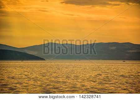 Sunset over Adriatic sea with Ciovo in foreground and Croatian coast in background, summertime.
