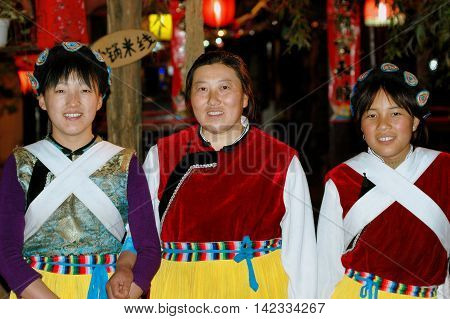 Lijiang China - April 18 2006: Three Chinese women wearing traditional Naxi clothing at a South Gate Square Restaurant