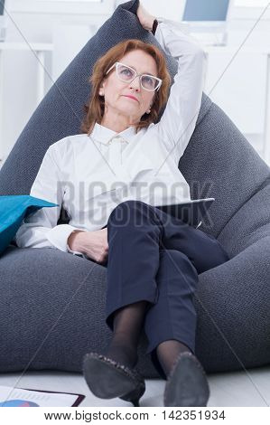 Businesswoman lying on bean bag chair and relax
