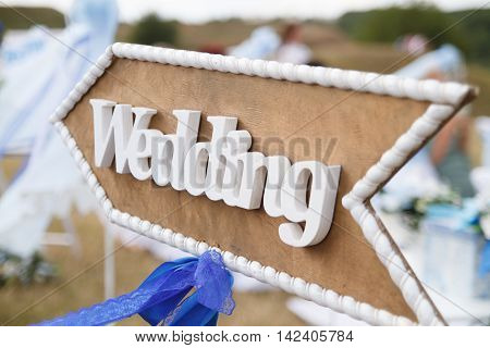 Wedding decor. Wooden plaque with the inscription Wedding. Wedding on a plate green background and a fountain. Wedding decorations,