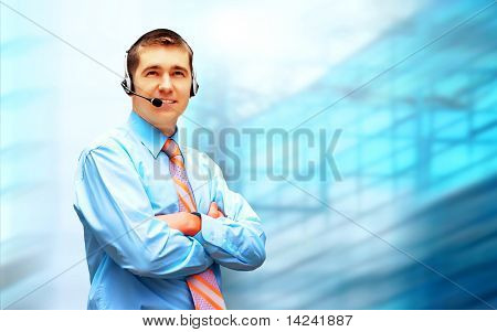 Homme d'affaires de bonheur en headphoness sur le fond d'architecture d'entreprise
