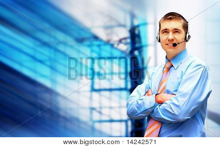 Homme d'affaires de bonheur en headphoness sur le fond d'architecture d'entreprise