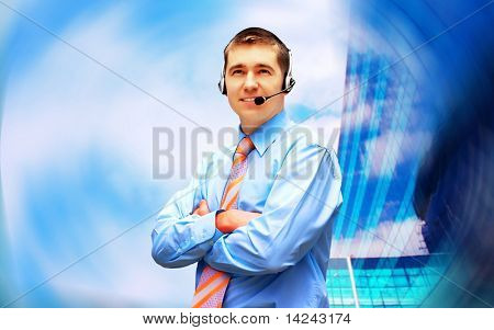 Homme d'affaires de bonheur en headphoness sur le fond d'architecture d'entreprise