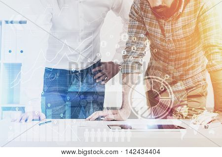 Engineers working in their office. Tablet on desk. They examine blueprints of building. Concept of scrupulous work. Toned image. Double exposure