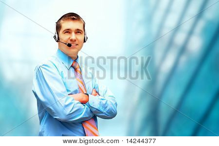 Homme d'affaires de bonheur en headphoness sur le fond d'architecture d'entreprise