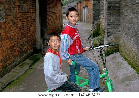 Pengzhou China - September 27 2006: Two little Chinese boys with their bicycle on Hua Lu (Old Street)