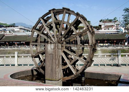 Dujiangyan China - November 1 2007: Miniature wooden water wheel on the quaiy running net to the Min River