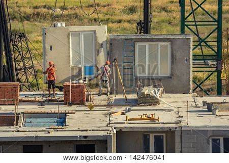 Worker setting up concrete panels during building construction