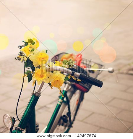 Vintage bicycle detail close up with flowrs over bokeh background