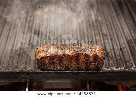 sizzling, smoking beef steak on a grill, horizontal
