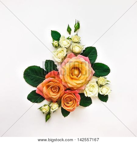 Decorative composition of pink orange and white roses green leaves on white background. Flat lay top view overhead view