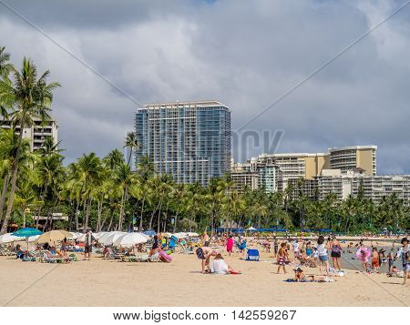 HONOLULU, USA - AUG 7: Sun lovers on Waikiki beach on August 7, 2016 in Honolulu, Usa. Waikiki beach is neighborhood of Honolulu, best known for white sand and surfing.