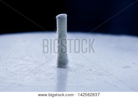 Close-up of the wick of a white unused candle cast in moonlight